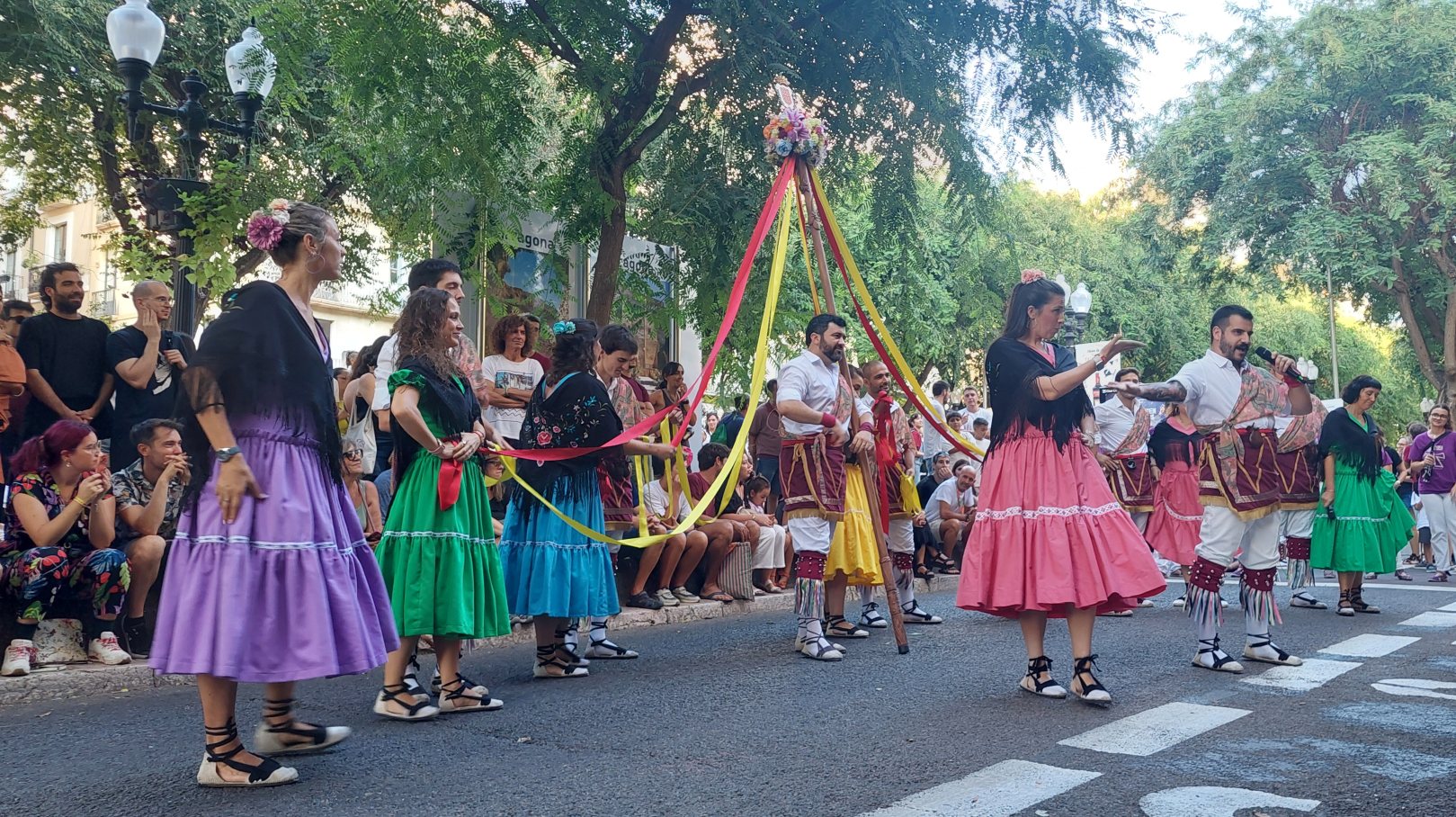 Un gitano dient els seus versos amb un micròfon enmig del ball, al carrer, davant del públic