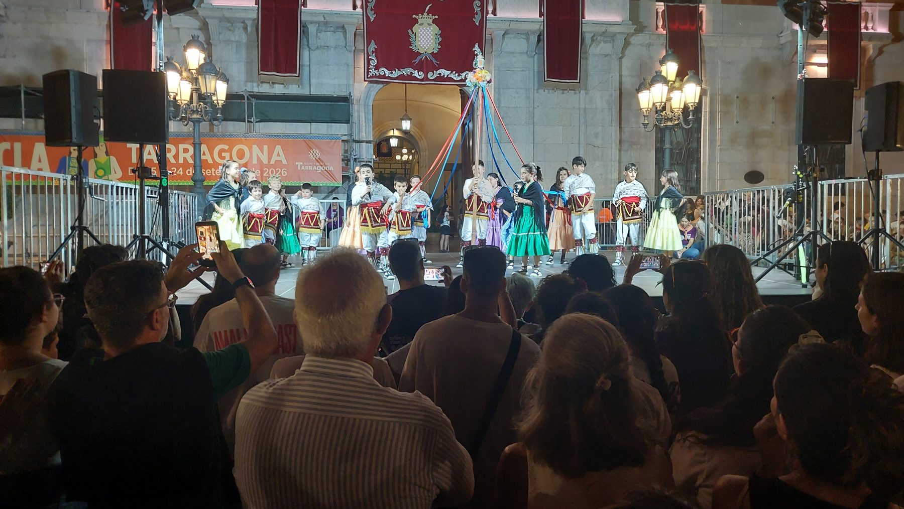 El Ball de Gitanes petit fent els parlaments a l'escenari, de nit, davant l'Ajuntament