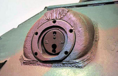 Montaje de la ametralladora frontal en un carro de combate con textura rugosa